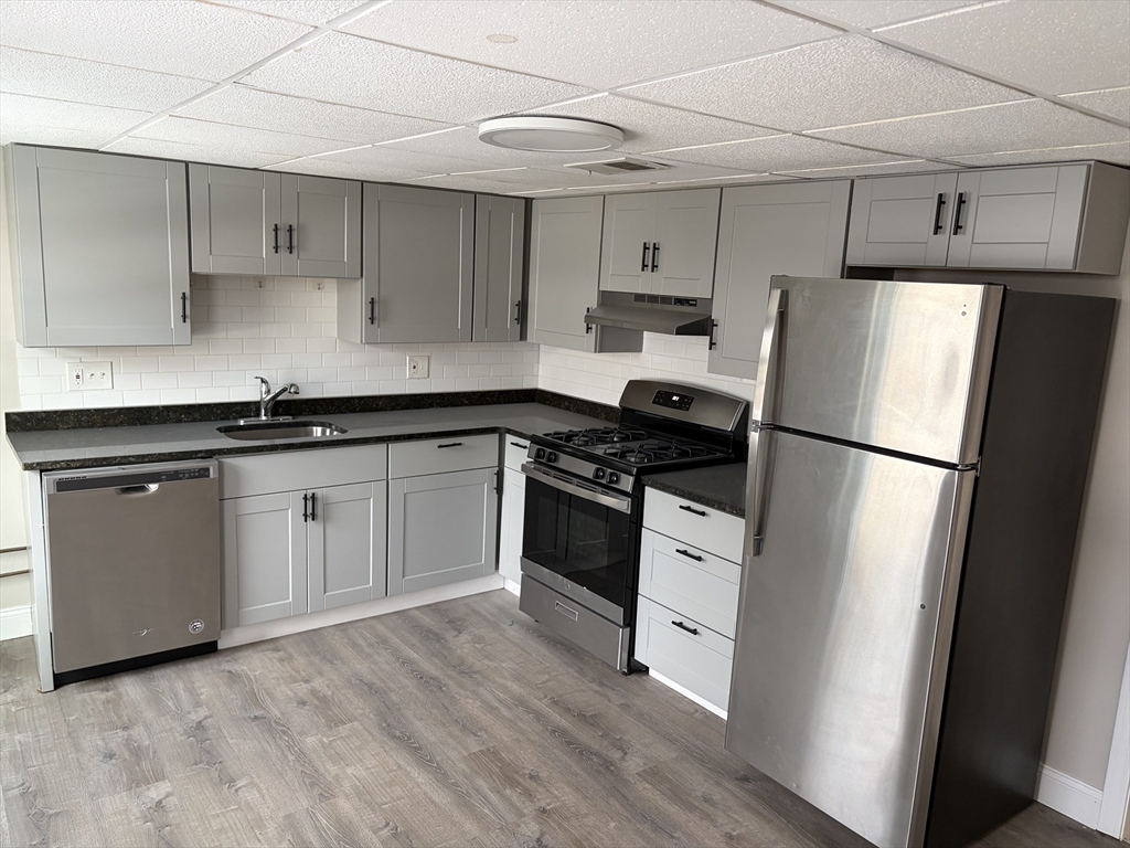a kitchen with a refrigerator sink and cabinets