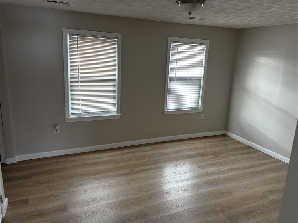 378 Union Street, Unit 2 Franklin, MA 02038 - Photo 2 of 5 an empty room with wooden floor and windows