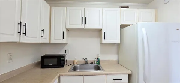 a kitchen with stainless steel appliances a sink a refrigerator and cabinets