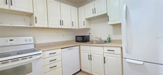 a kitchen with white cabinets and white appliances