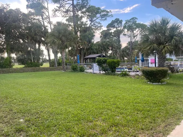 a view of a house with backyard and sitting area