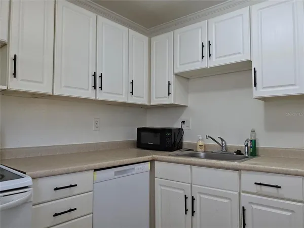 a kitchen with white cabinets and a stove