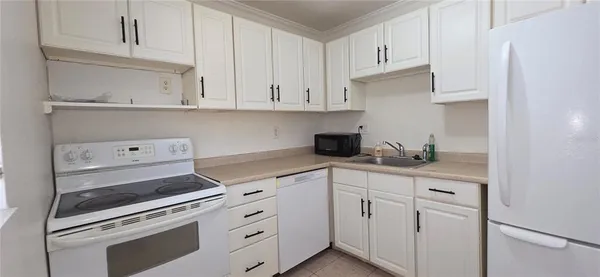 a kitchen with white cabinets and sink