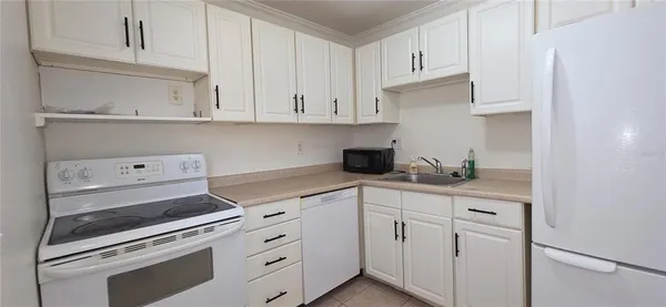 a kitchen with white cabinets and white appliances