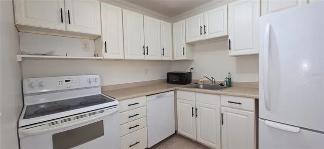 a kitchen with white cabinets and white appliances