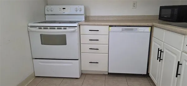 a white refrigerator freezer and a stove sitting inside of a kitchen