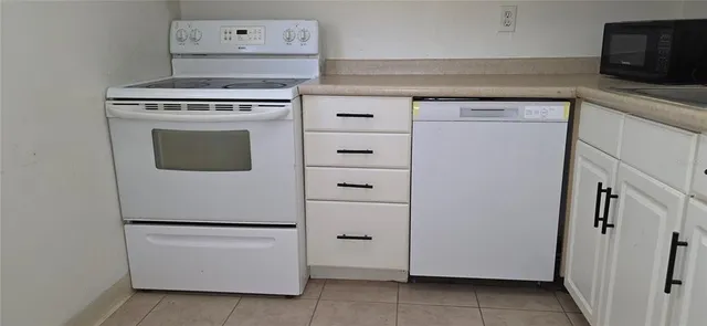 a white refrigerator freezer and a stove sitting inside of a kitchen