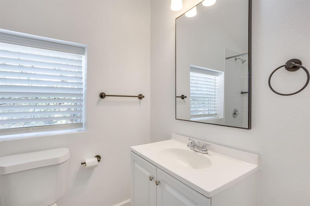 6940 Hatch Road Fort Worth, TX 76135 - Photo 37 of 40 White vanity with integrated sink, chrome faucet, framed mirror, and window with blinds