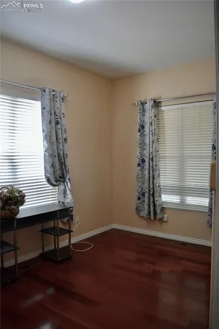 a view of a room with wooden floor and a window