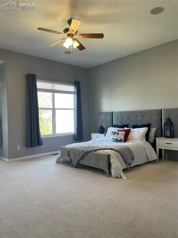 a spacious bedroom with a bed and a chandelier