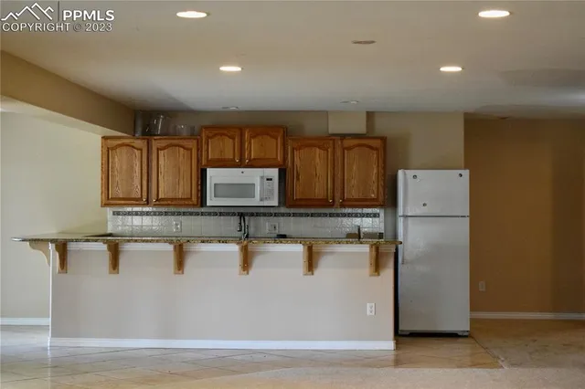 a view of a refrigerator a sink and dishwasher with wooden floor