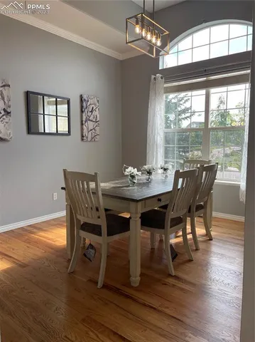 a dining room with furniture a chandelier and wooden floor