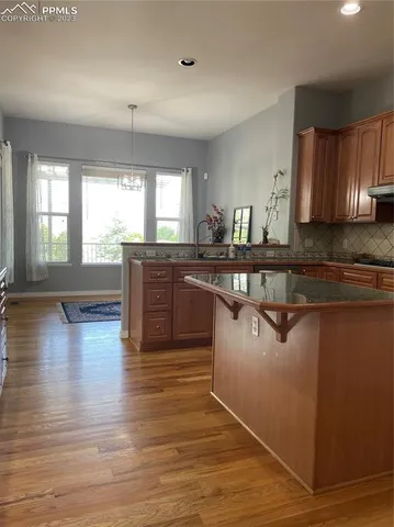 a large kitchen with wooden floors and stainless steel appliances