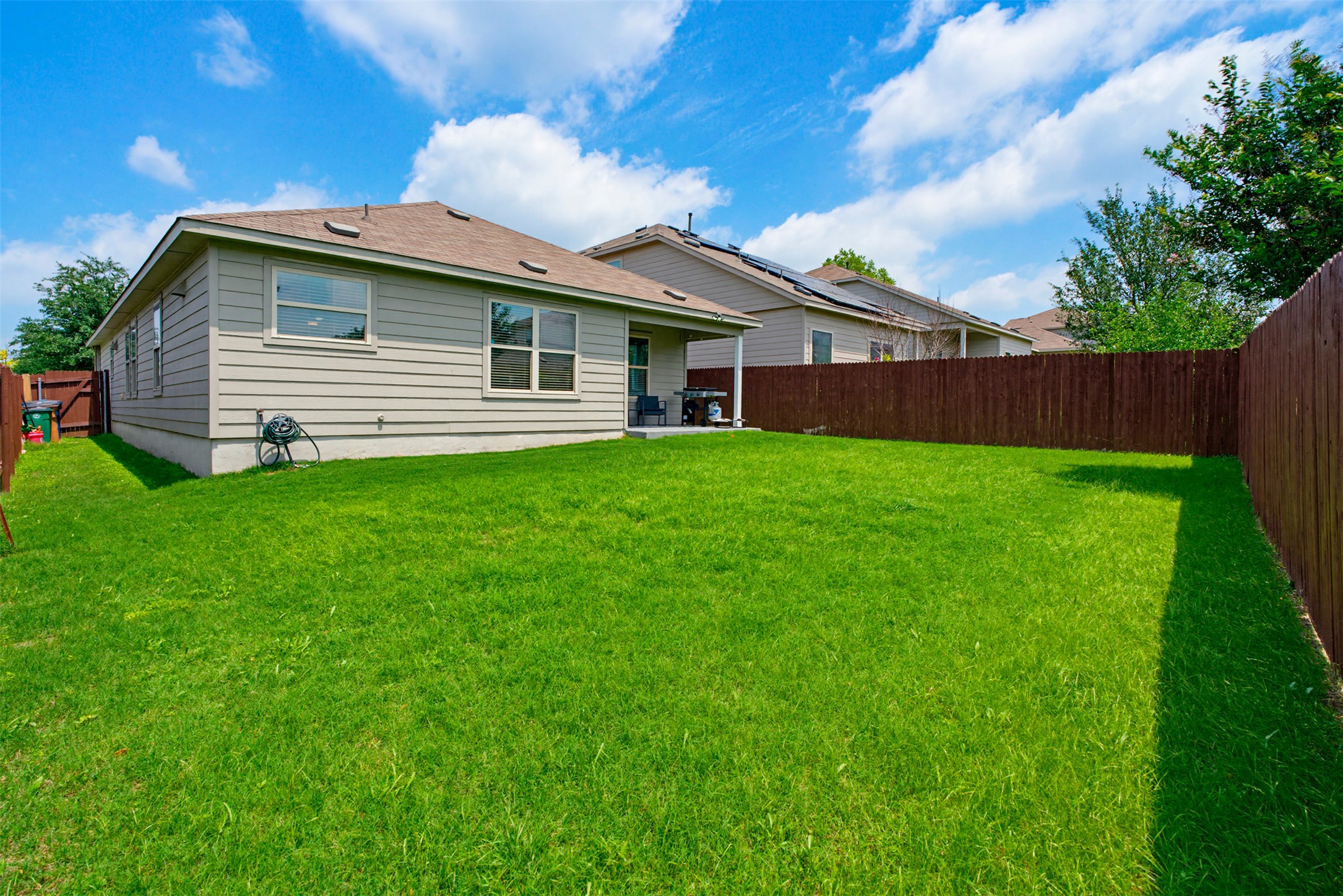 5705 Southerner Way Austin, TX 78747 - Photo 20 of 22 A spacious, verdant yard with fencing for privacy, offering ample room for recreation and outdoor living.