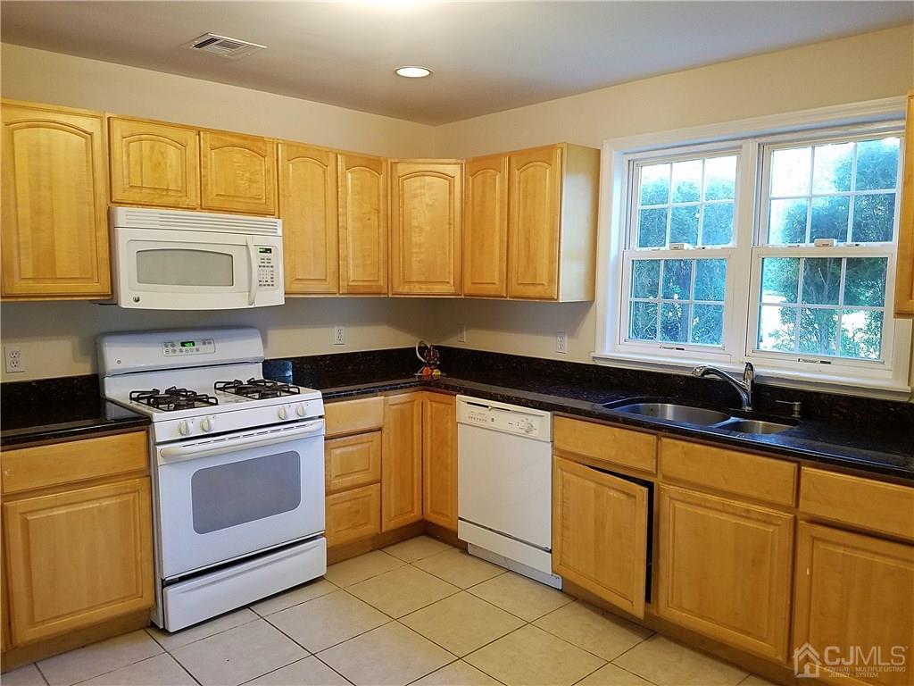 26 Baxter Road Edison, NJ 08817 - Photo 6 of 22 a kitchen with granite countertop cabinets stainless steel appliances a sink and a window