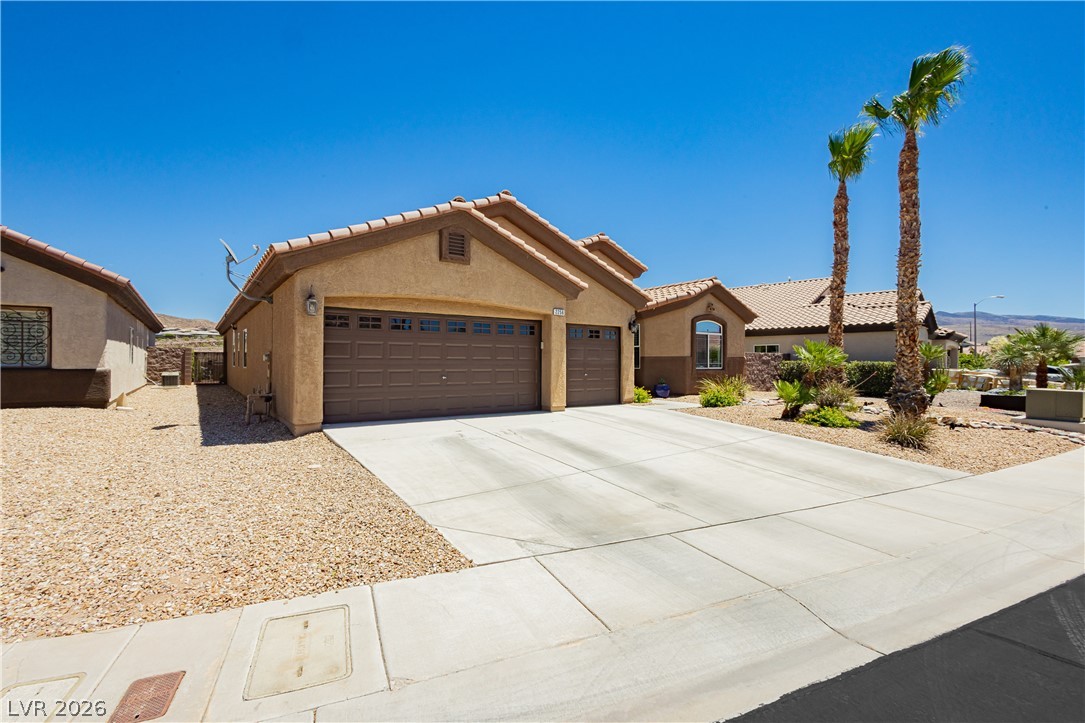 2256 Dogwood Ranch Avenue Henderson, NV 89052 - Photo 4 of 51 A well-maintained desert landscape frames this welcoming residence, boasting a wide driveway and attached garages.