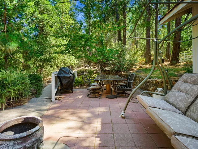 a dining room with wooden floor a chandelier a wooden table and chairs