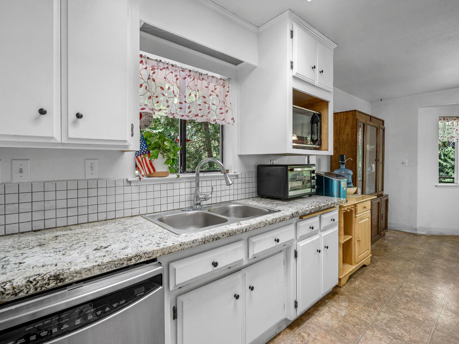 18960 Quailrun Fiddletown, CA 95629 - Photo 24 of 32 a kitchen with granite countertop a sink stainless steel appliances white cabinets and a window
