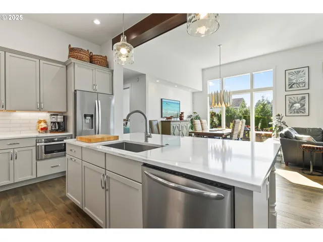 a kitchen with stainless steel appliances granite countertop a sink a stove and a refrigerator