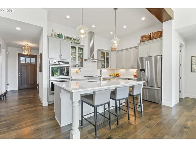 a kitchen with stainless steel appliances a dining table chairs refrigerator and stove