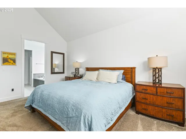 a bedroom with a bed a dresser and painting