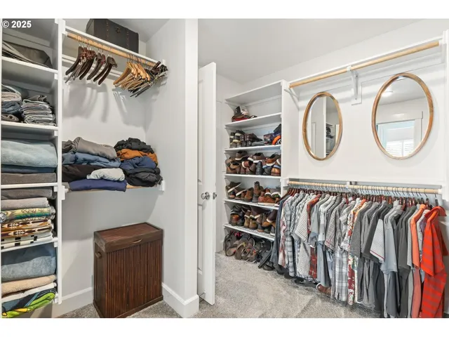 a view of walk in closet with clothes and shoes