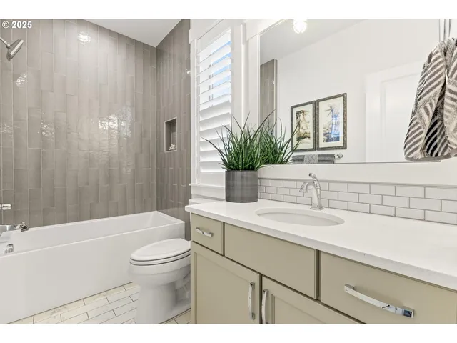 a bathroom with a sink a toilet a tub and shower