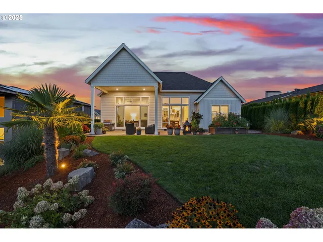 a front view of a house with a yard and potted plants
