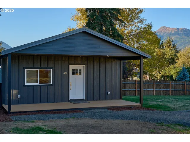 a view of backyard of house with wooden fence