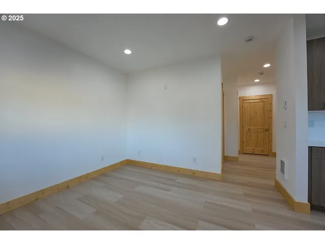 a view of an empty room with wooden floor