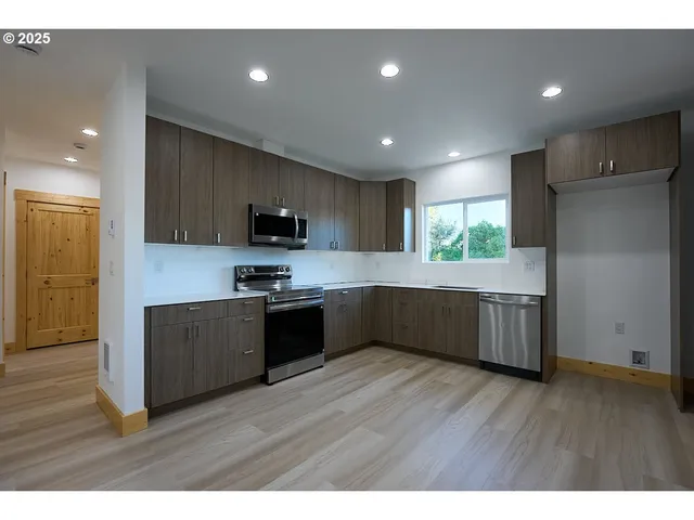 a kitchen with wooden floors and wooden cabinets