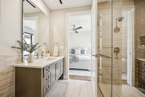 a spacious bathroom with a double vanity sink a mirror and shower