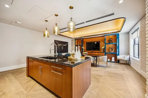 a living room with stainless steel appliances granite countertop furniture a fireplace and a flat screen tv