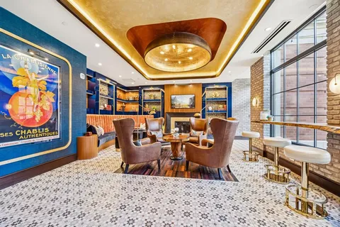 a living room with furniture a rug and a floor to ceiling window