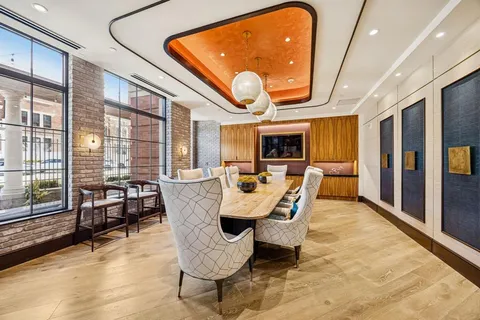 a dining room with furniture a large window and wooden floor