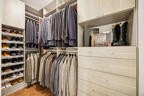 a view of walk in closet with clothes and shoes