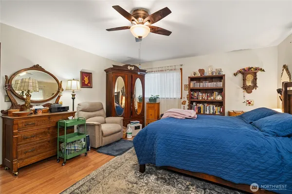 a bedroom with a bed a dresser and book shelf