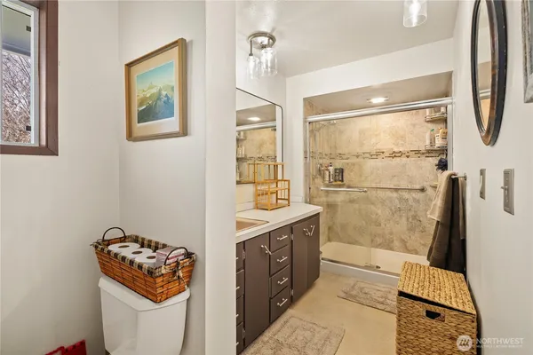 a bathroom with a granite countertop sink a mirror and shower
