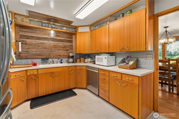 a kitchen with stainless steel appliances a sink window and cabinets