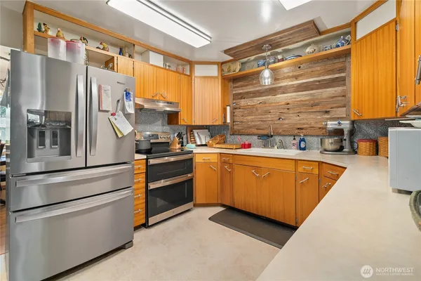 a kitchen with stainless steel appliances granite countertop a refrigerator a stove and a microwave