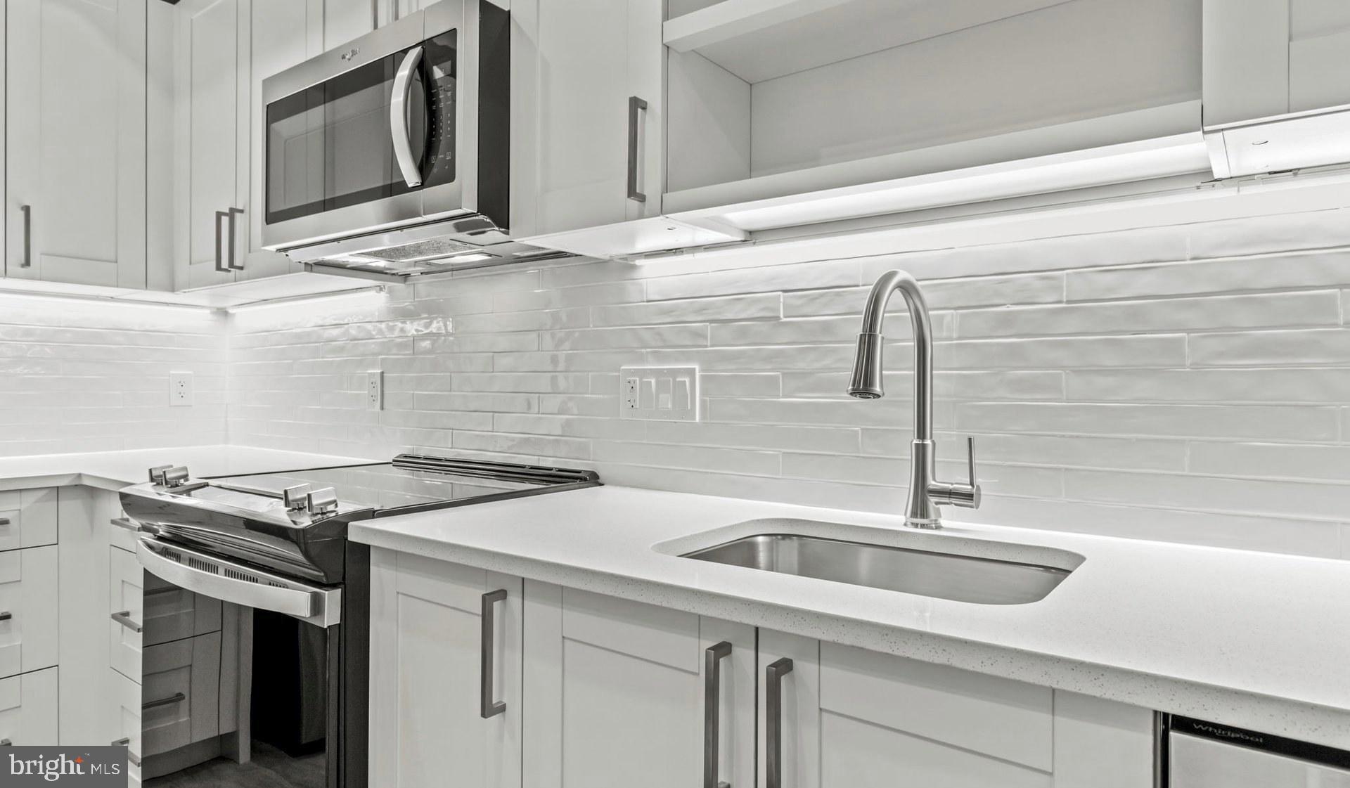 4000 Wisconsin Avenue Northwest, Unit 4K236 Washington, DC 20016 - Photo 23 of 54 a kitchen with stainless steel appliances granite countertop a sink and a microwave