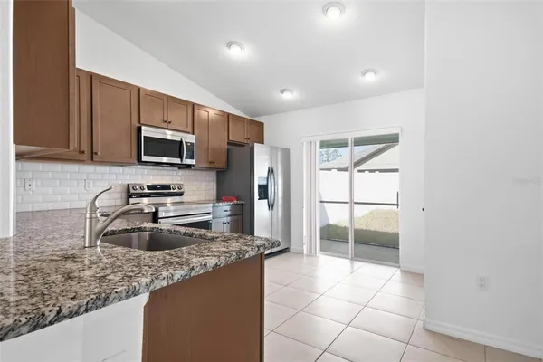 a kitchen with stainless steel appliances granite countertop a sink and a stove