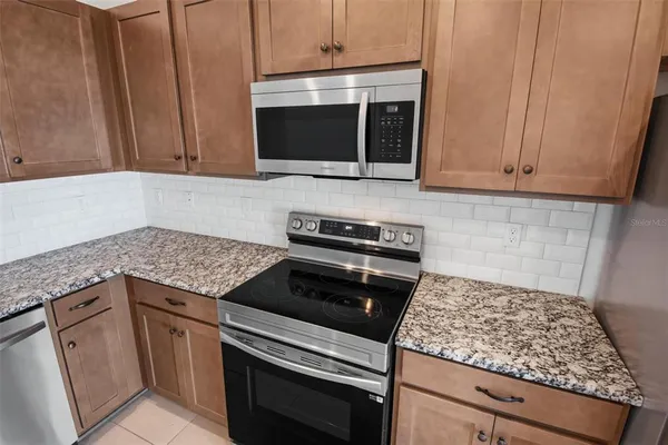 a kitchen with granite countertop a sink and a stove