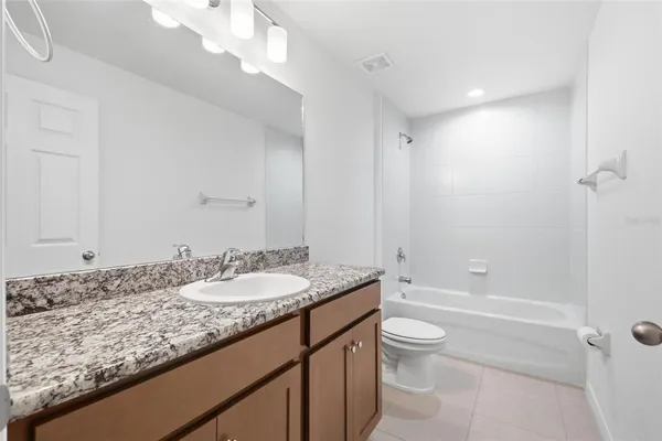 an empty room with kitchen view and windows