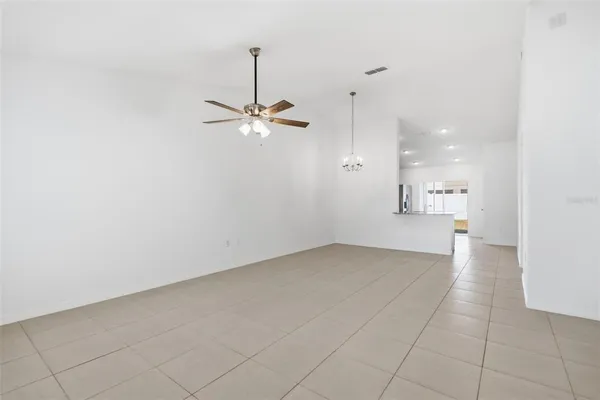 an empty room with fan and windows