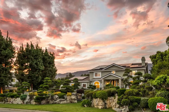 a front view of a house with a yard and potted plants