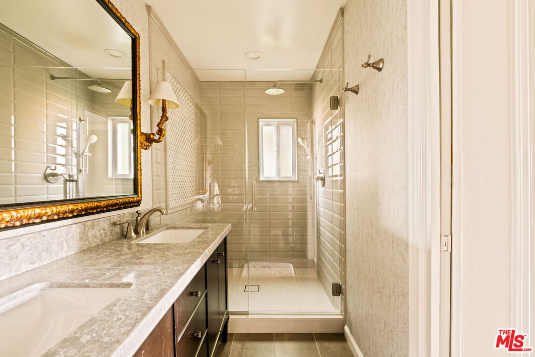 1047 East Pomello Drive Claremont, CA 91711 - Photo 52 of 73 a bathroom with a granite countertop sink a mirror and a shower