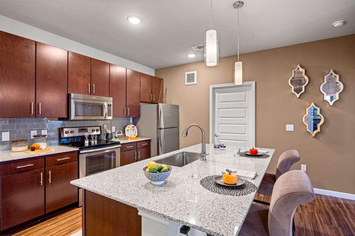9308 South 1st Beach, Unit 830 Austin, TX 78748 - Photo 9 of 23 a kitchen with stainless steel appliances granite countertop a sink refrigerator and stove