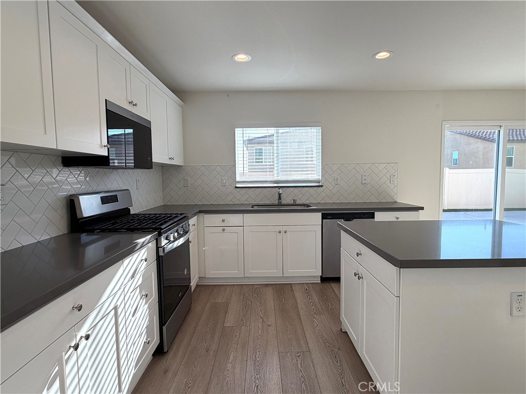 7631 Rubyred Gln Drive Riverside, CA 92507 - Photo 3 of 17 a kitchen with a sink stove top oven and cabinets