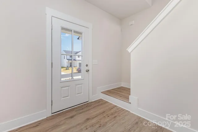an empty room with wooden floor cabinet and mirror